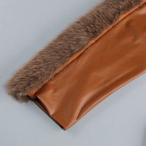 Gros plan sur la bordure en fourrure marron et la texture cuir de la robe