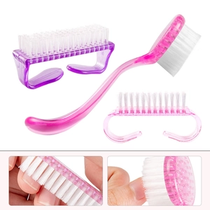 Pink and purple plastic nail cleaning brushes with white bristles in a professional set