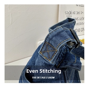 Detail view of denim fabric with yellow stitching and plastic buckle on shoulder bag