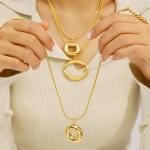 Minimalist gold-plated geometric circle pendant necklace shown on model in a layered look