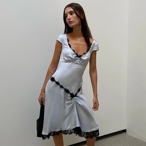 Dettaglio di abito in raso celeste con delicati pizzi neri e fiocco decorativo