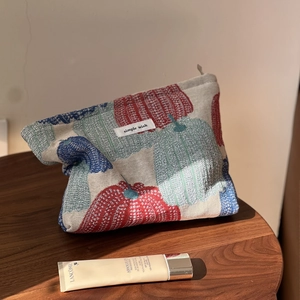 Detail of fabric cosmetic bag with pumpkin jacquard texture and simple wish woven label