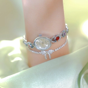 Elegant silver quartz watch with colorful gemstones on a luxury silk background