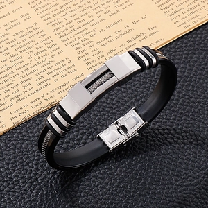 Close-up of stainless steel clasp on a black silicone bracelet for men over a newspaper