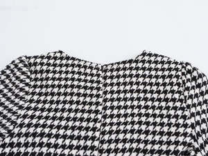 Détail du col rond et du tissu en tweed pied-de-poule noir et blanc sur la robe