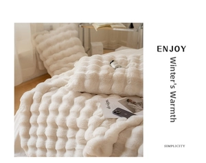 Detailed macro view of white faux rabbit fur blanket with 3D bubble textured plush fabric