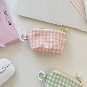 Detailed view of plaid mini coin purse with daisy embroidery and pearl zipper charm