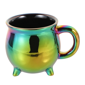 Detailed view of iridescent rainbow ceramic cauldron mug with three feet and black interior