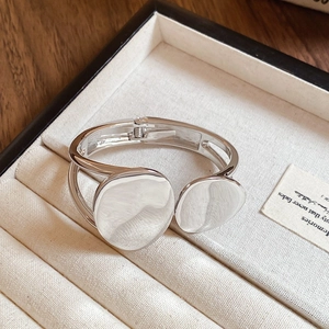 Close-up of irregular double oval silver bracelet inside a beige velvet jewelry box