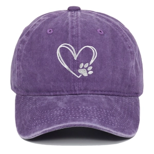 Close-up of heart and paw embroidery on purple washed cotton baseball cap with vintage texture