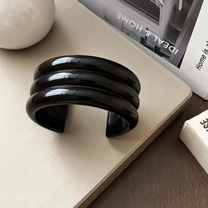 Macro shot of the black three-layered geometric resin cuff bracelet with polished finish