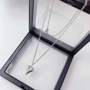 Close-up of a silver 3D heart pendant necklace displayed on a black jewelry box