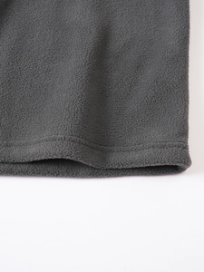 Detailed close-up of dark grey fleece fabric showing high-quality double-stitched hem seams