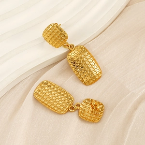 Detailed macro view of gold geometric earrings with modern mesh texture and metallic shine