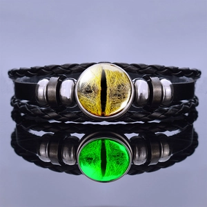 Detailed close-up of luminous dragon eye leather bracelet with polished metal beads and reflection