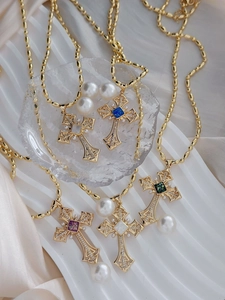 Detailed macro view of baroque cross pendants with colorful gemstones and pearls