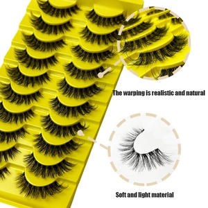 Realistic wispy faux mink eyelashes with natural curl in a yellow display tray