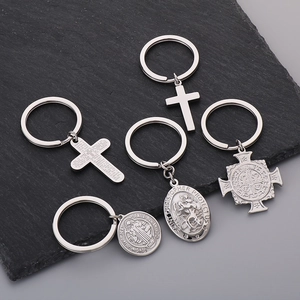 Detail of five religious stainless steel keychains with Saint Christopher medals on black stone