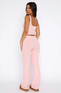 Detail of pink ribbed knit two-piece set featuring a sleeveless crop top and high-waisted pants