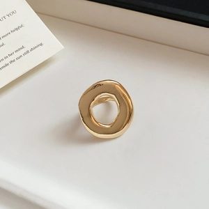 Macro detail of high-polish gold irregular ring with fluid lava organic texture