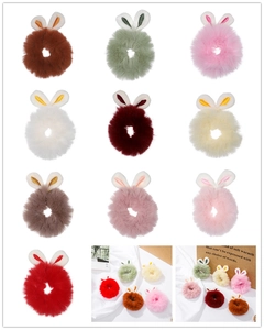 Detail showing plush bunny ear scrunchies in various pastel colors and soft faux fur texture