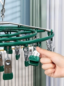 Detail view of steel clothes hanger with green soft rubber clips for no-mark drying