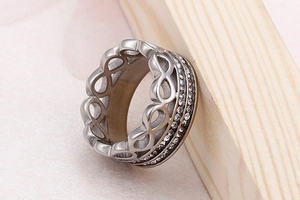 Macro shot of silver infinity ring with double row cubic zirconia on wood stand