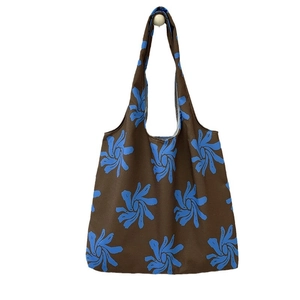 Brown canvas tote bag with blue orchid patterns, spacious design for travel or school