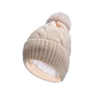 Detailed view of cream knit beanie featuring thick faux fur lining and a fluffy pom-pom