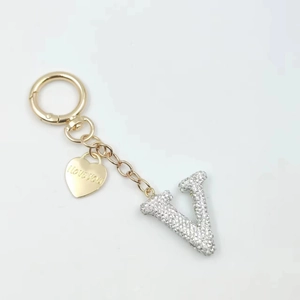 Detail of crystal letter V keychain with golden I love you heart charm and ring