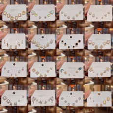 Detailed display of 16 assorted earring sets featuring pearls, crystals and motifs