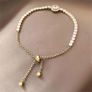 Close-up of golden adjustable tennis bracelet with sparkling zircon halo centerpiece