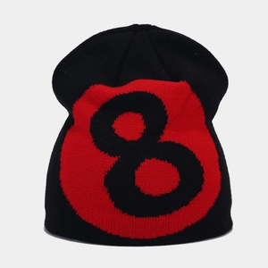 Detail of knitted black beanie featuring a red and black number 8 ball jacquard pattern