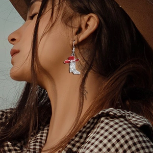 Detail shot of cowboy boot earrings with red hat design and sparkling white crystals
