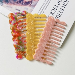 Chic marble pattern acetate wave hair combs in three vibrant colors on a magazine