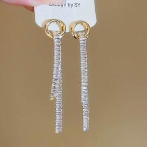 Detail of gold tassel earrings with interlocking circles and sparkling rectangular zircons