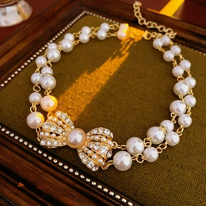 Detailed shot of vintage double-layer pearl bracelet with rhinestone bow on velvet
