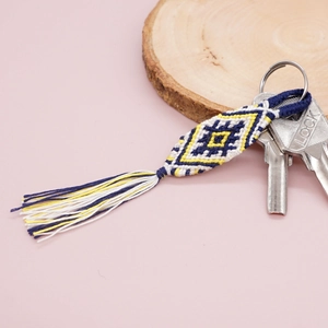 Ethnic woven keychain with blue and yellow diamond pattern and cotton tassels