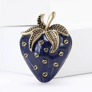 Macro shot of retro dark blue enamel strawberry brooch with golden texture and details