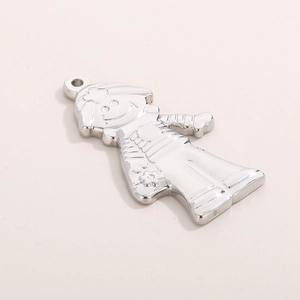 Macro detail of silver stainless steel cartoon boy pendant with smooth polished finish