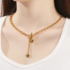 Detailaufnahme der goldenen OT-Schnalle-Halskette mit Herzanhängern am Model