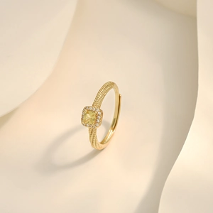 Detail of adjustable gold ring featuring a yellow cushion-cut halo stone and textured band