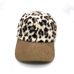 Detail of winter leopard print plush baseball cap with brown corduroy brim and soft texture