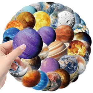 Macro shot of colorful planet stickers showing a hand peeling a purple cosmic planet decal