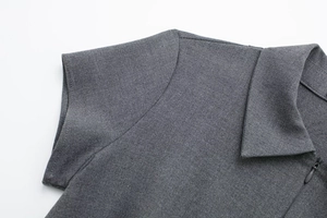 Detail van de grijze polokraag met ritssluiting en schoudernaden met korte mouwen