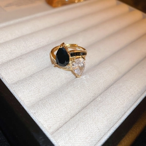 Macro detail of gold-plated dragon ring featuring pear-cut black and white zircons