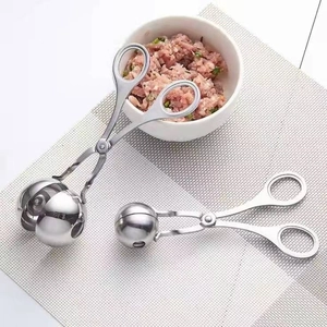 Set of two stainless steel meatball makers in different sizes on a light placemat