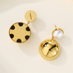 Macro detail of gold sphere earrings with white pearl pendants on light background