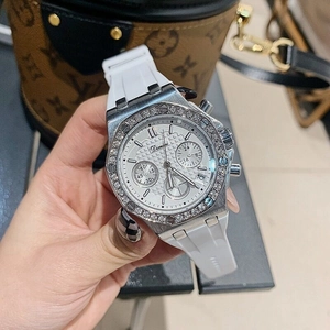 Close-up of a silver watch featuring a diamond bezel and three functional sub-dials