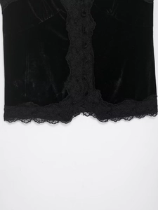 Detail eines schwarzen Samt-Tops mit filigranem Spitzenbesatz und passenden Knöpfen